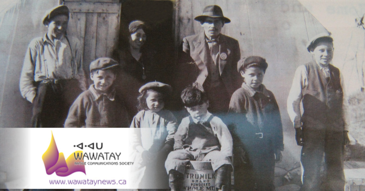 This faded historical photo features my grandfather James Kataquapit who was Chief of Attawapiskat in 1945. Here we see him standing with a hat and pin signifying his leadership. His wife Janie Kataquapit is standing at the door. Chief Kataquapit was also a veteran of the First World War. From L-R are his children: Thomas, Marius, Celine, David, Gabriel and Alex. Missing are brothers George and Leo.